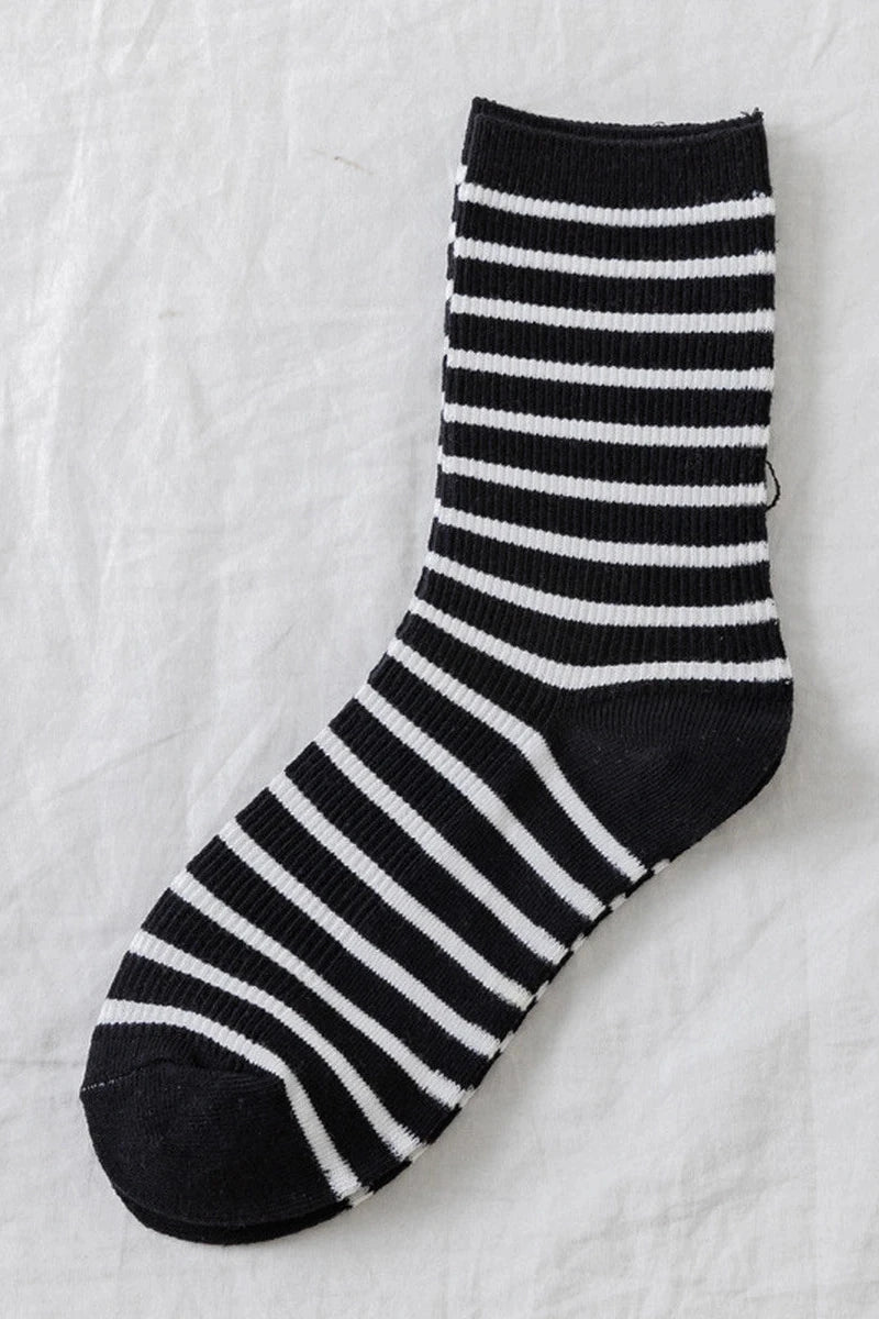 Black and white striped sock on a textured white background