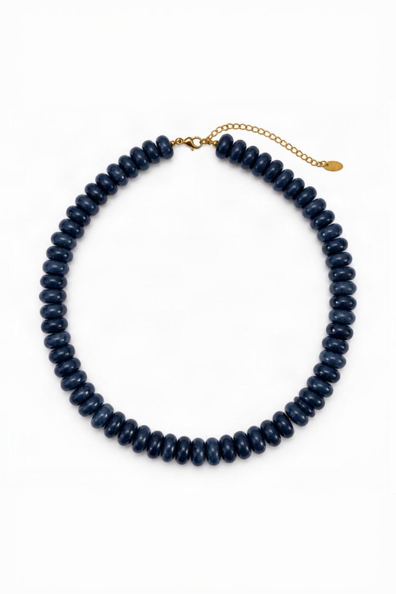 A dark navy blue beaded collar necklace with a gold clasp and extender chain, displayed on a clean white background.