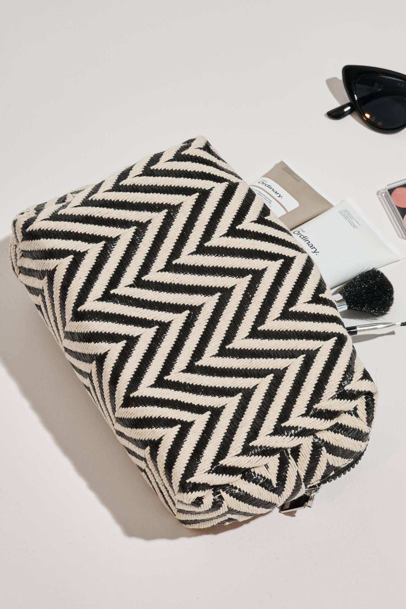 Makeup bag with makeup items on a light surface