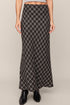 Person wearing a long plaid skirt on a plain background