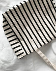 Black and white striped tote bag on a white background