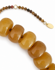 Bracelet with brown beads and gold clasp on a white background