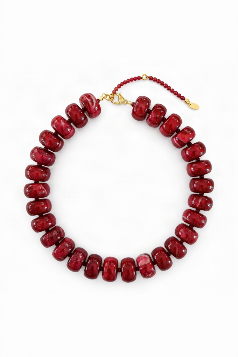 Red beaded necklace with a gold clasp on a white background