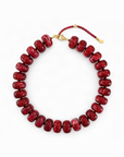 Red beaded necklace with a gold clasp on a white background