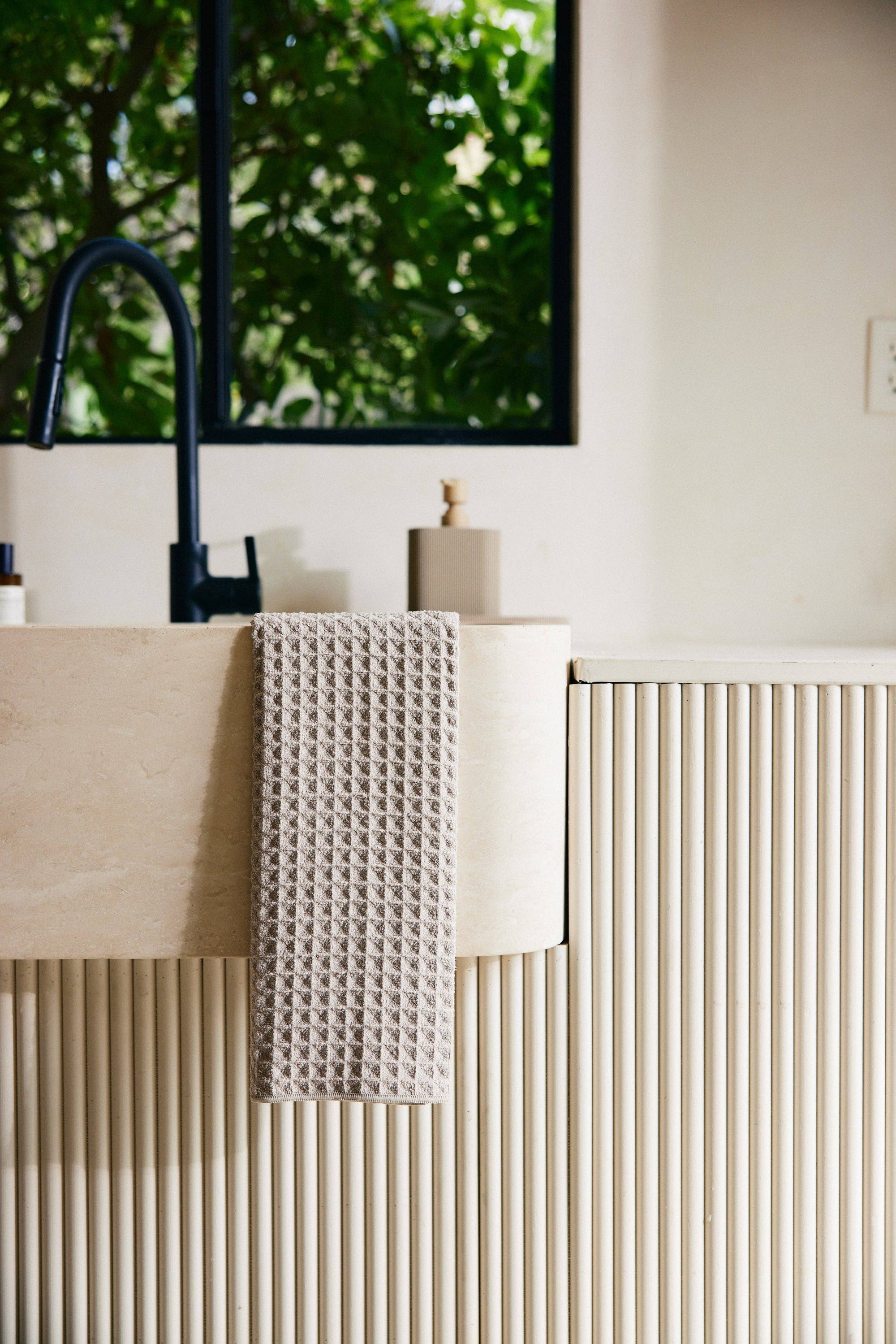 Bathroom setting with a sink, towel, and decorative items.