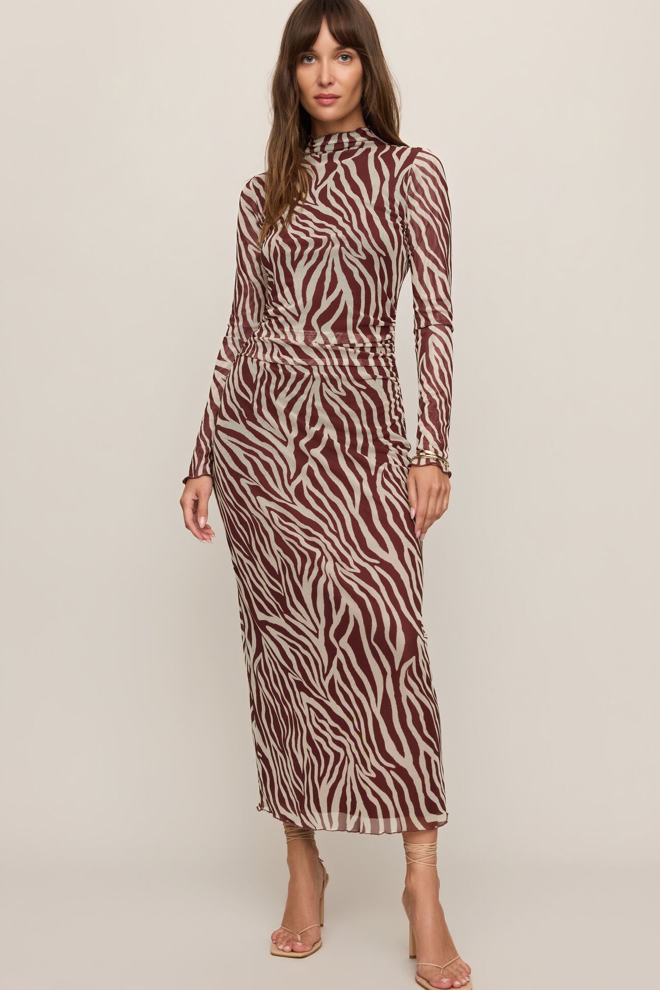 Woman wearing a zebra print dress on a plain background