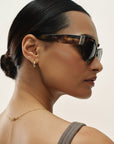 Woman wearing sunglasses with a neutral background