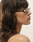 Woman wearing sunglasses with a neutral background