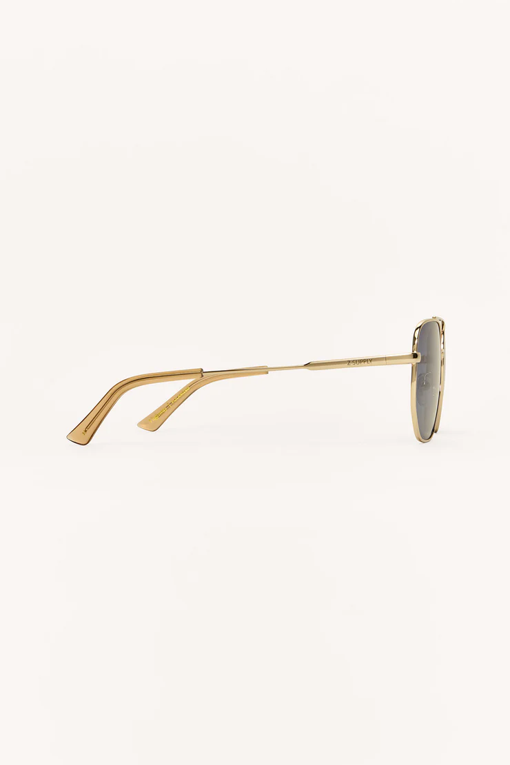 Gold-framed sunglasses with gray lenses on a white background