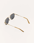 Gold-framed sunglasses with dark lenses on a white background
