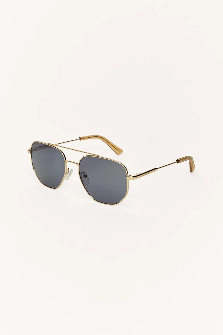 Gold-framed sunglasses with dark lenses on a white background