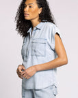 Woman wearing a light blue denim outfit on a plain background