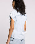 Person wearing a light blue denim outfit on a plain background