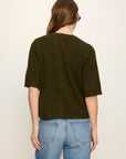 Person wearing a dark green t-shirt and blue jeans on a plain background