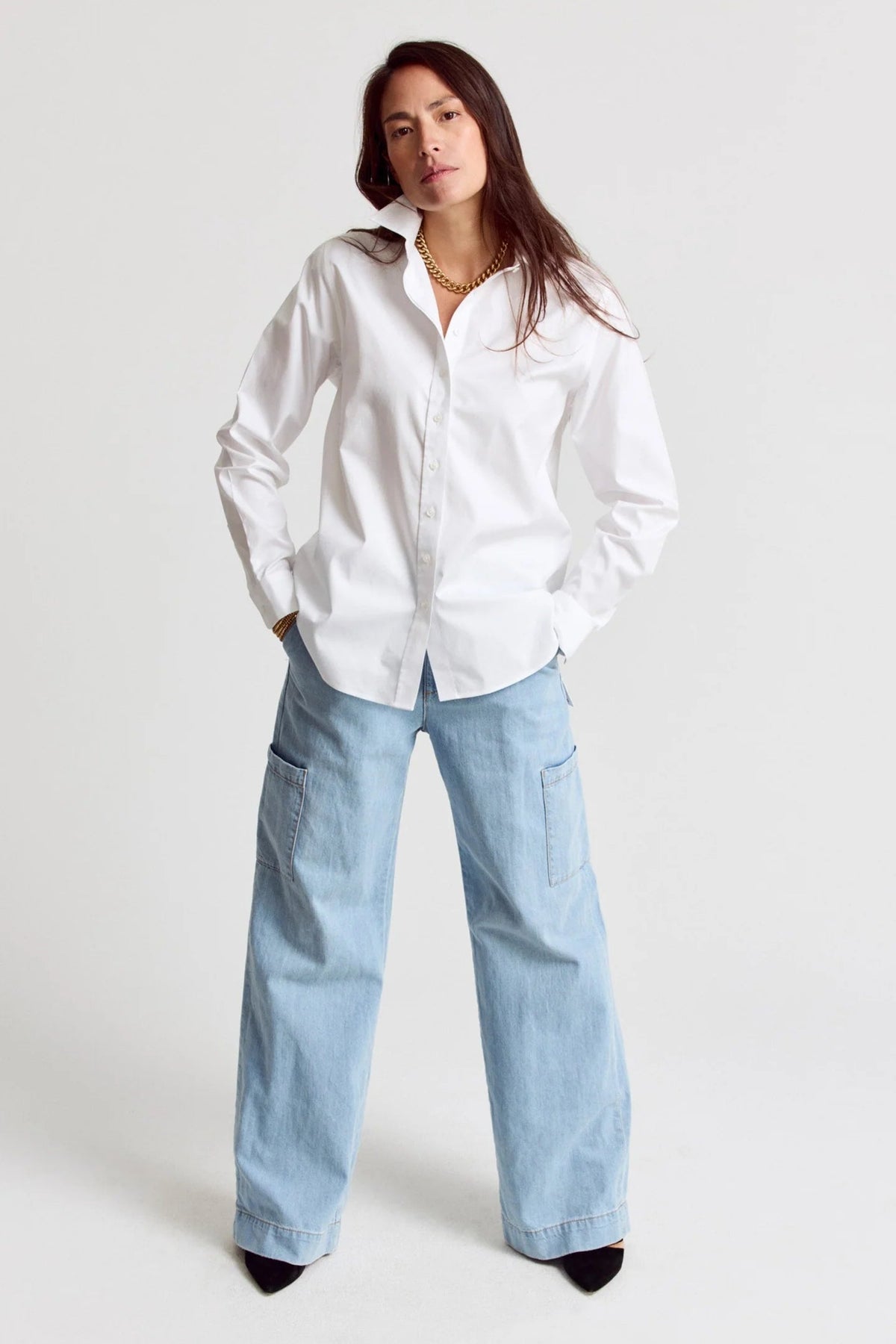 Woman wearing a white shirt and light blue jeans on a white background