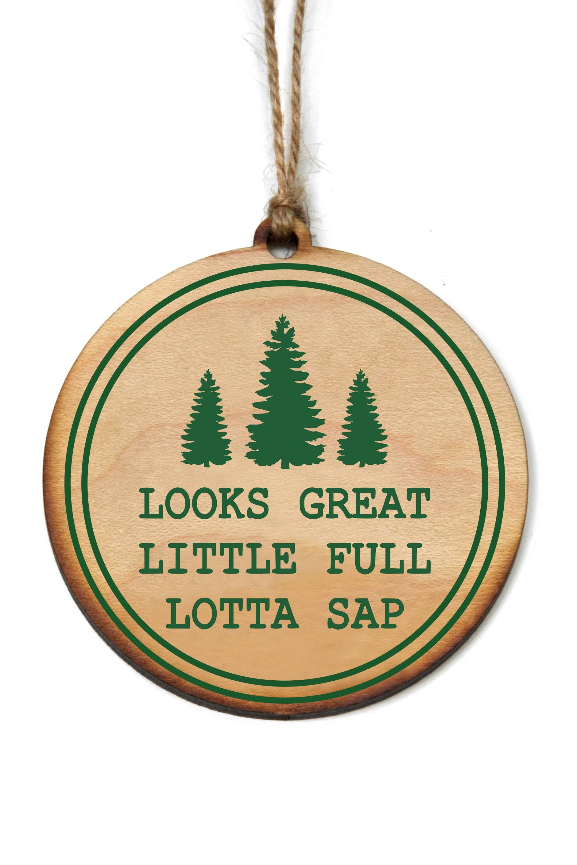 A wooden holiday ornament with green text and tree illustrations in a circular design, attached to a string for hanging.